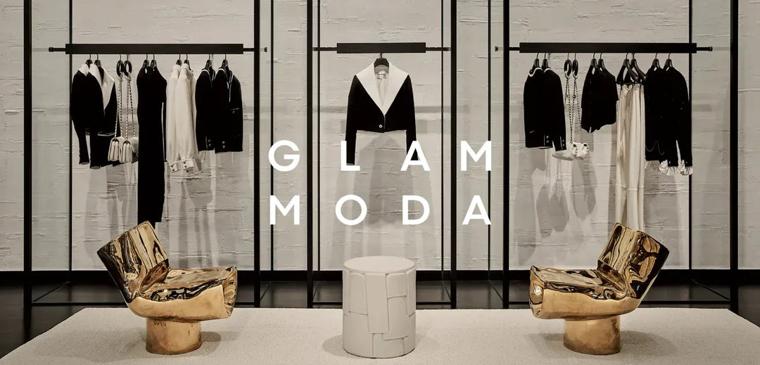 Modern boutique interior with black and white clothing on racks, gold metallic chairs, and white stool