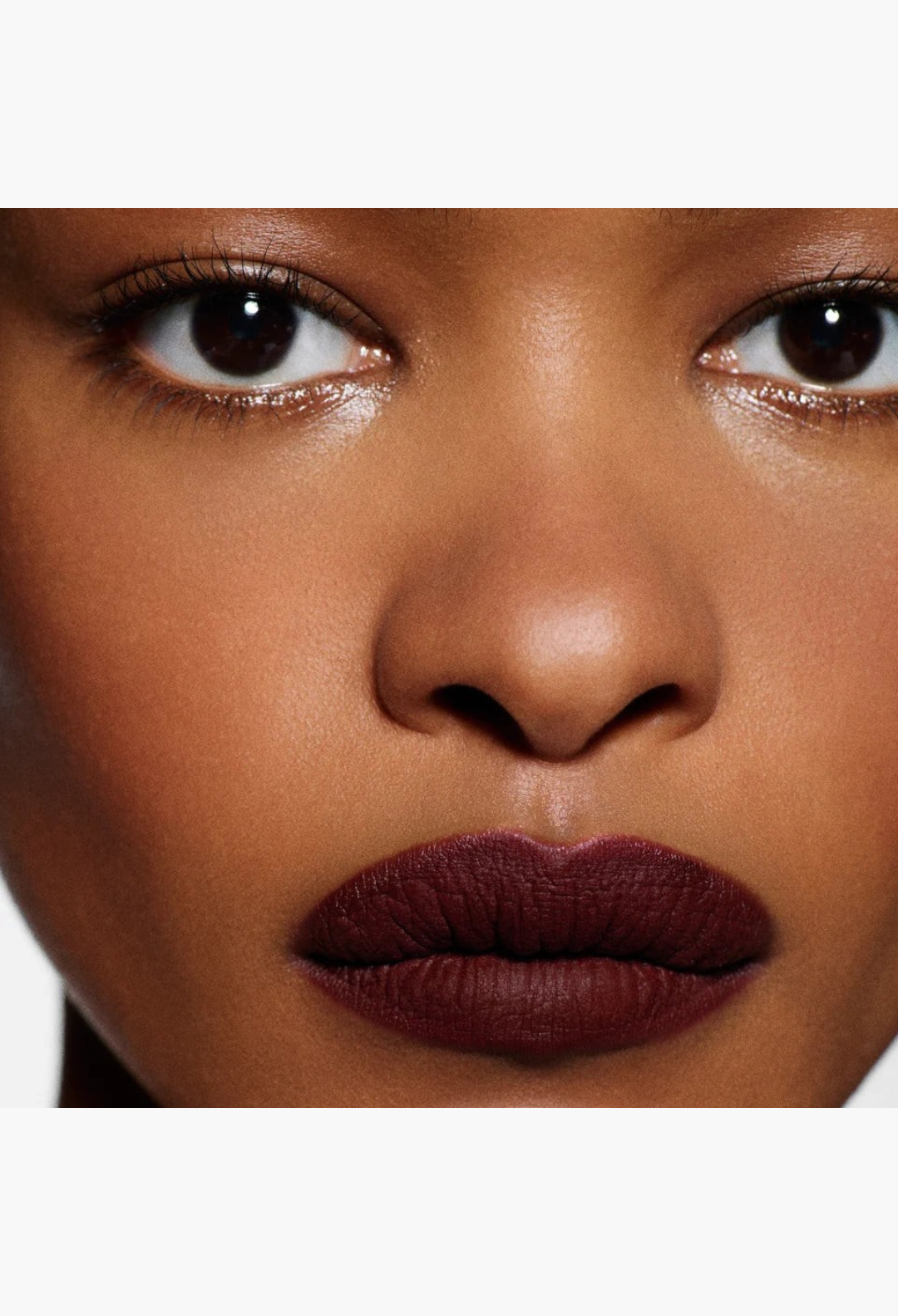 GLAM MODA Rouge Victoria matte lipstick applied to lips in a bold white shade on a model with deep skin tone