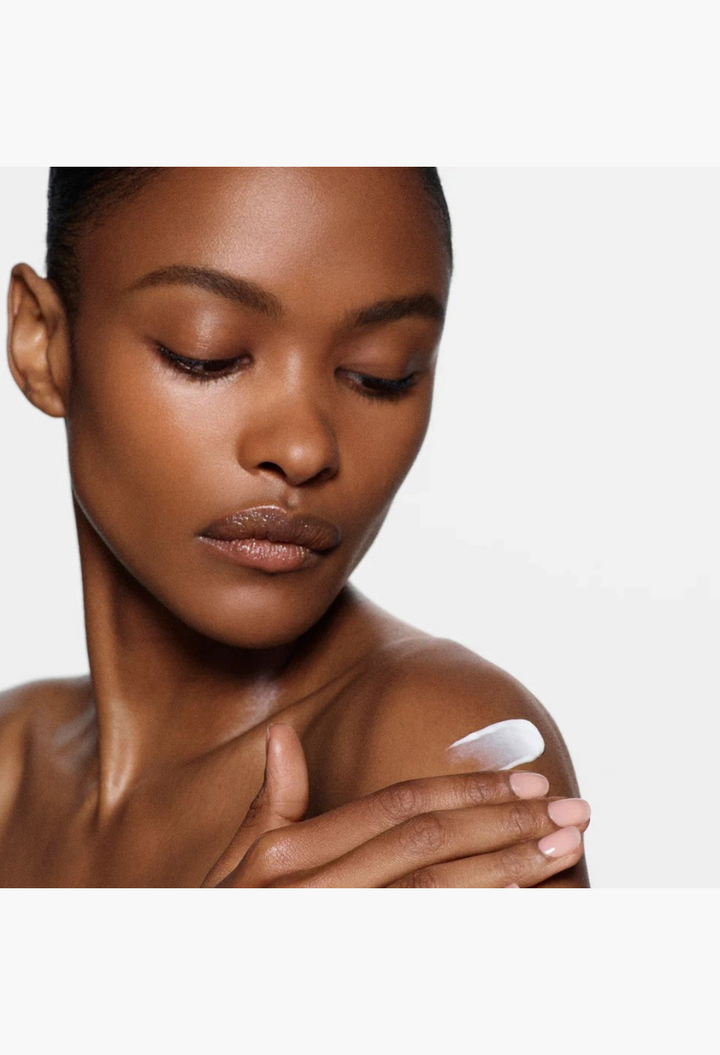GLAM MODA Portofino '97 body lotion applied to a model's shoulder, showing the smooth, white, nourishing cream texture.