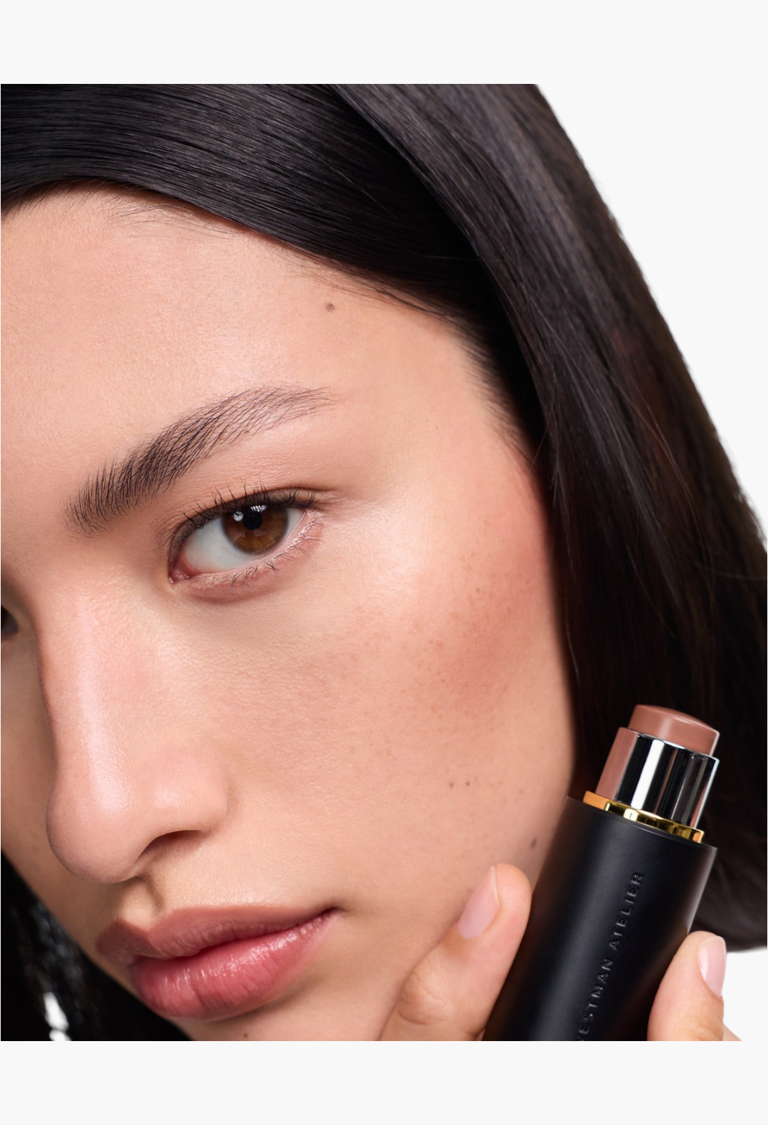 GLAM MODA Face Trace Contour Stick being held by a model to show the creamy brown product texture and application.