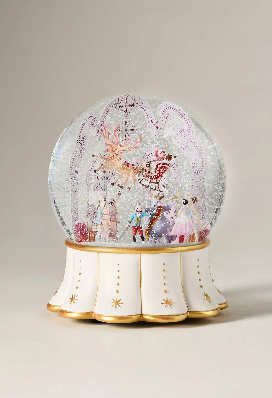 GLAM MODA New York City Ballet musical snow globe with holiday characters and an ivory and gold sculpted base.