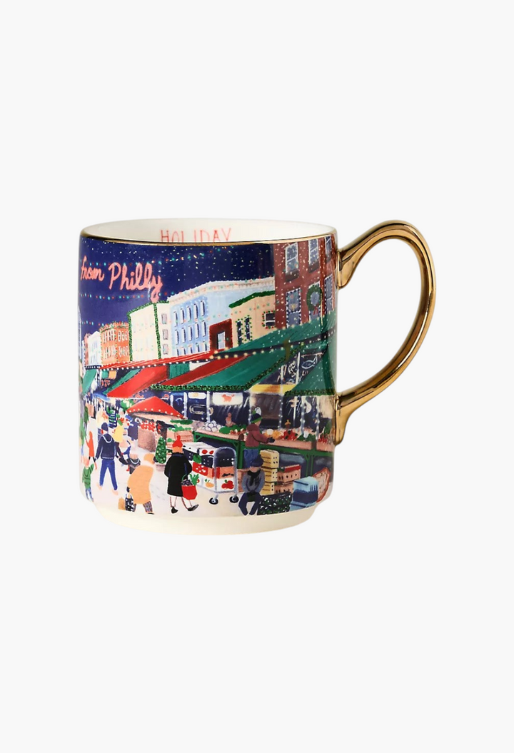 GLAM MODA Holiday in the City stoneware mug featuring a festive street scene with hand-painted gold handle accents.