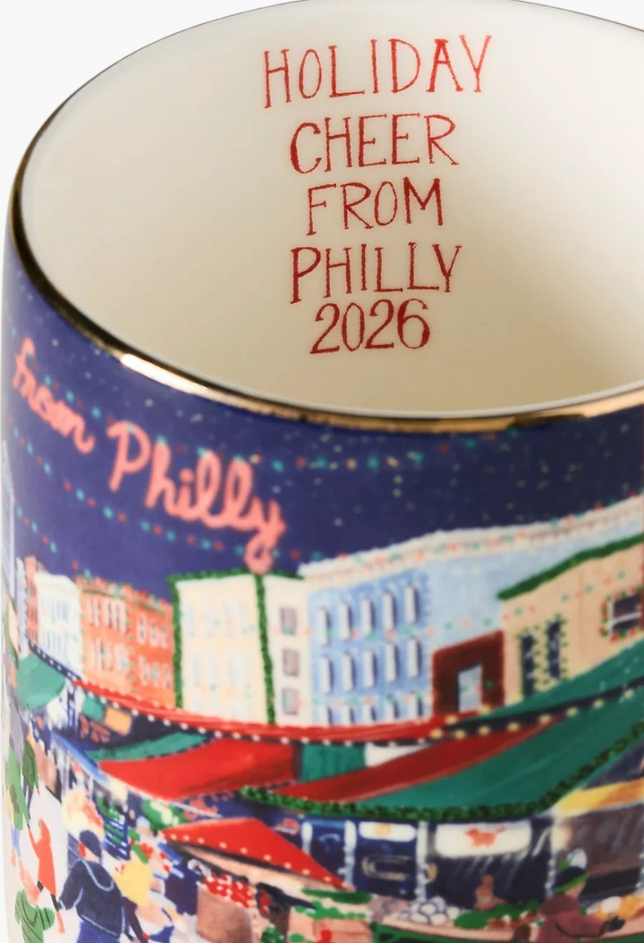 GLAM MODA Holiday in the City stoneware mug featuring a festive Philly streetscape illustration and gold rim.