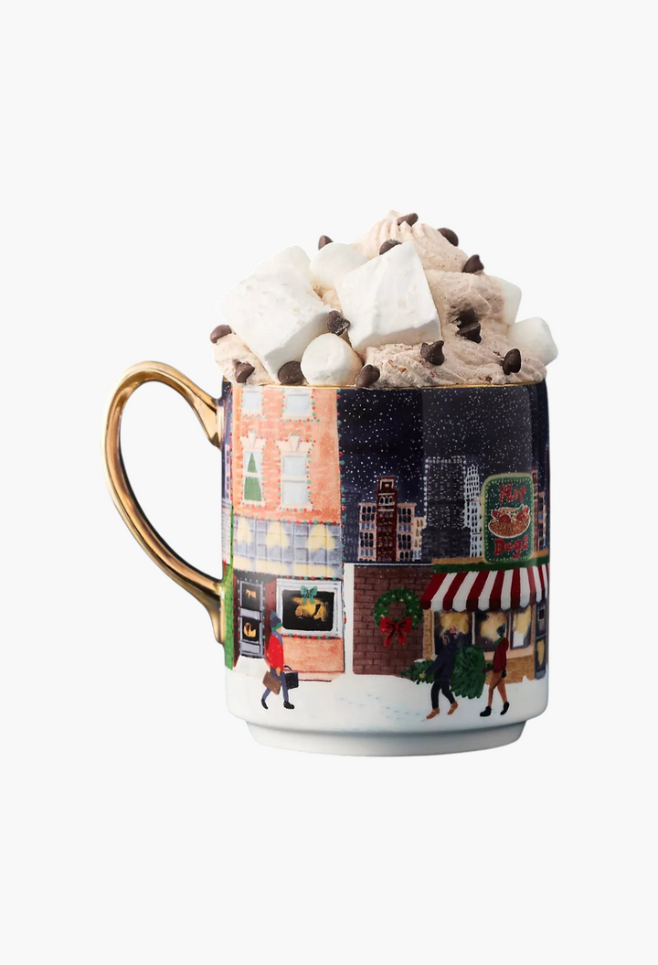 GLAM MODA Holiday in the City stoneware mug featuring a festive snowy streetscape and gold handle with hot cocoa.