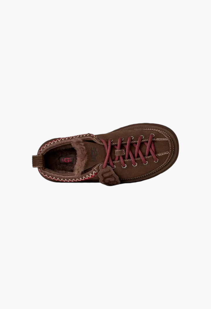 GLAM MODA brown suede lace-up slipper with sheepskin lining, red ticked laces, and a removable UGG logo charm.