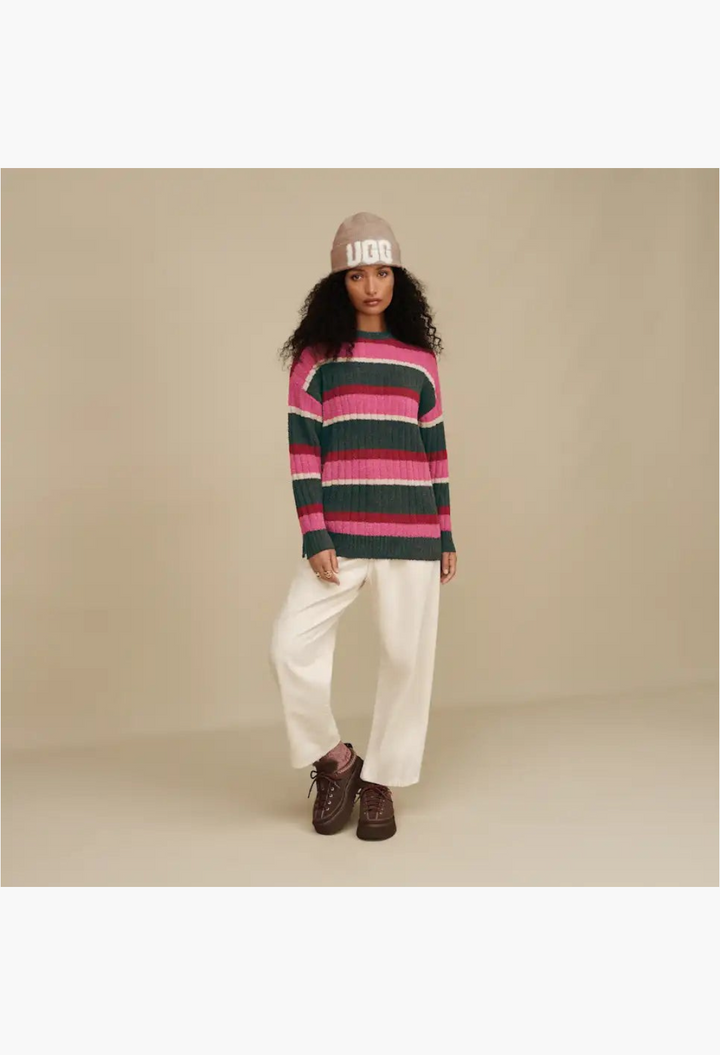 GLAM MODA model wearing a striped sweater, cream trousers, and brown suede lace-up slippers with sheepskin lining.
