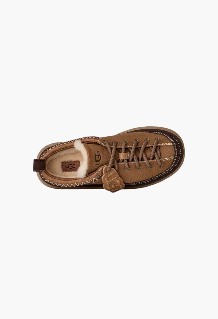 GLAM MODA women's brown suede lace-up slipper with sheepskin lining, platform sole, and removable UGG logo charm.