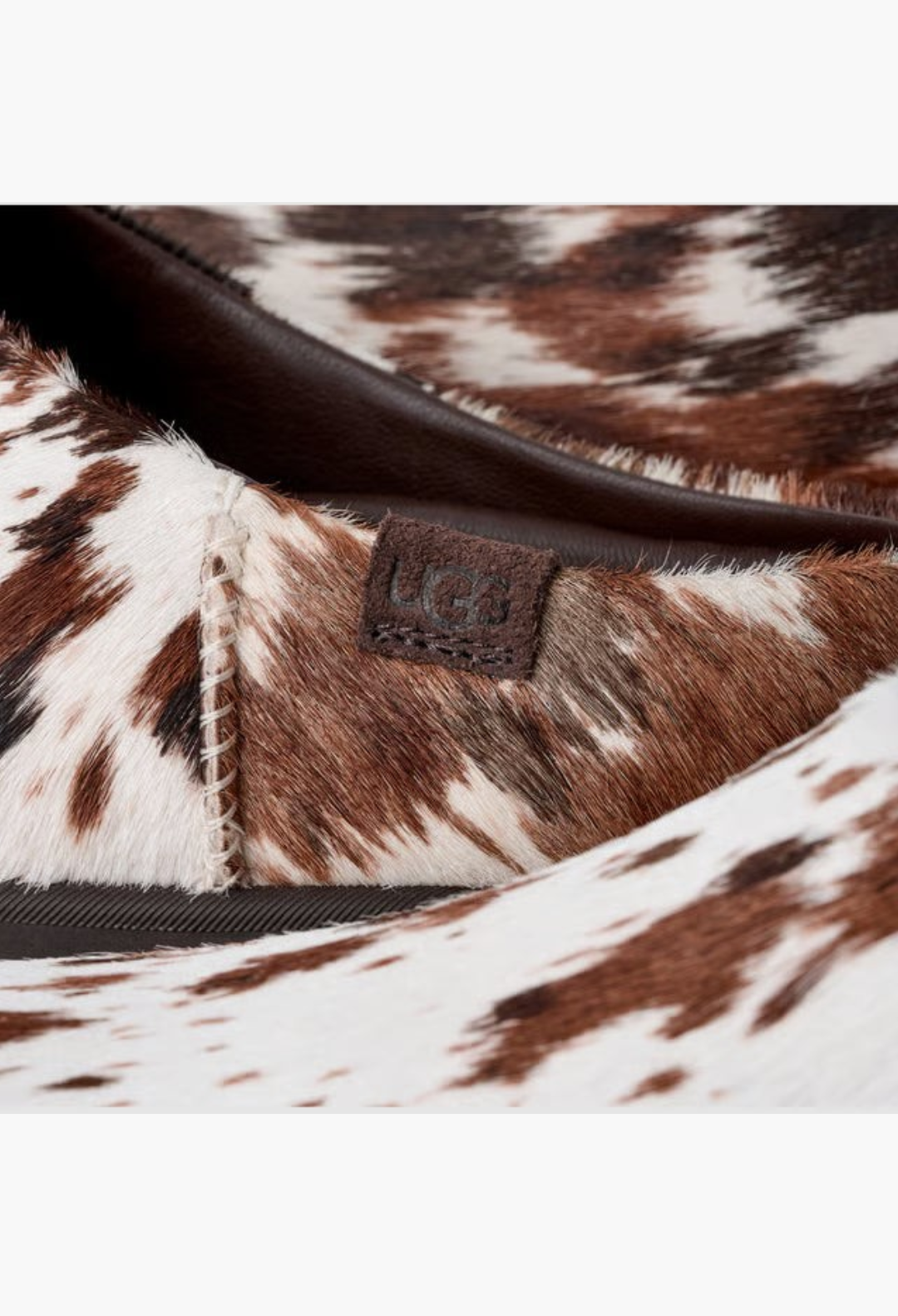 GLAM MODA Otzo Western Clog featuring hand-painted brown and white cow hair upper with embossed UGG logo leather tag