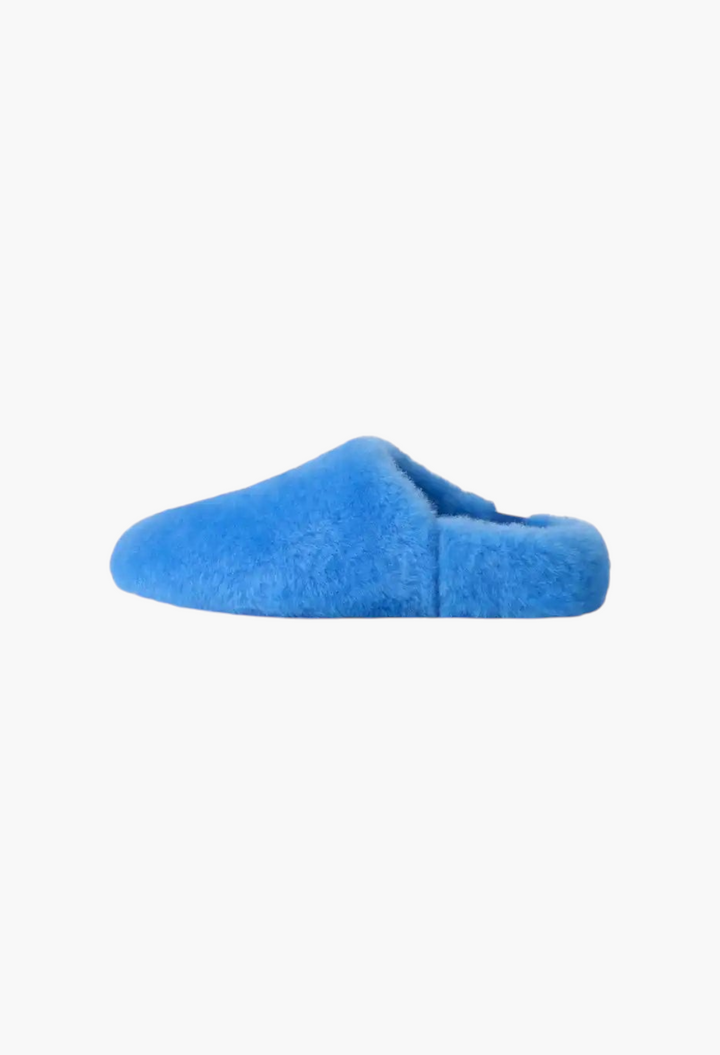 GLAM MODA Elea fluffed slip-on slipper in bright blue sheepskin with a minimalist silhouette and rubber outsole.