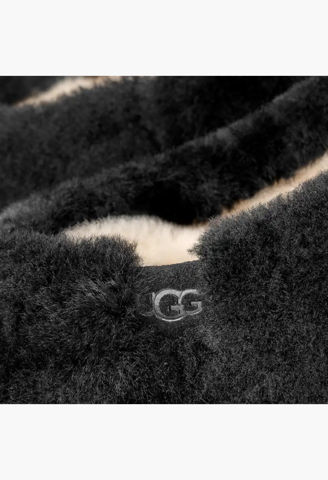 GLAM MODA black sheepskin Elea slip-on slipper featuring a soft fluffy texture and embossed UGG logo detail