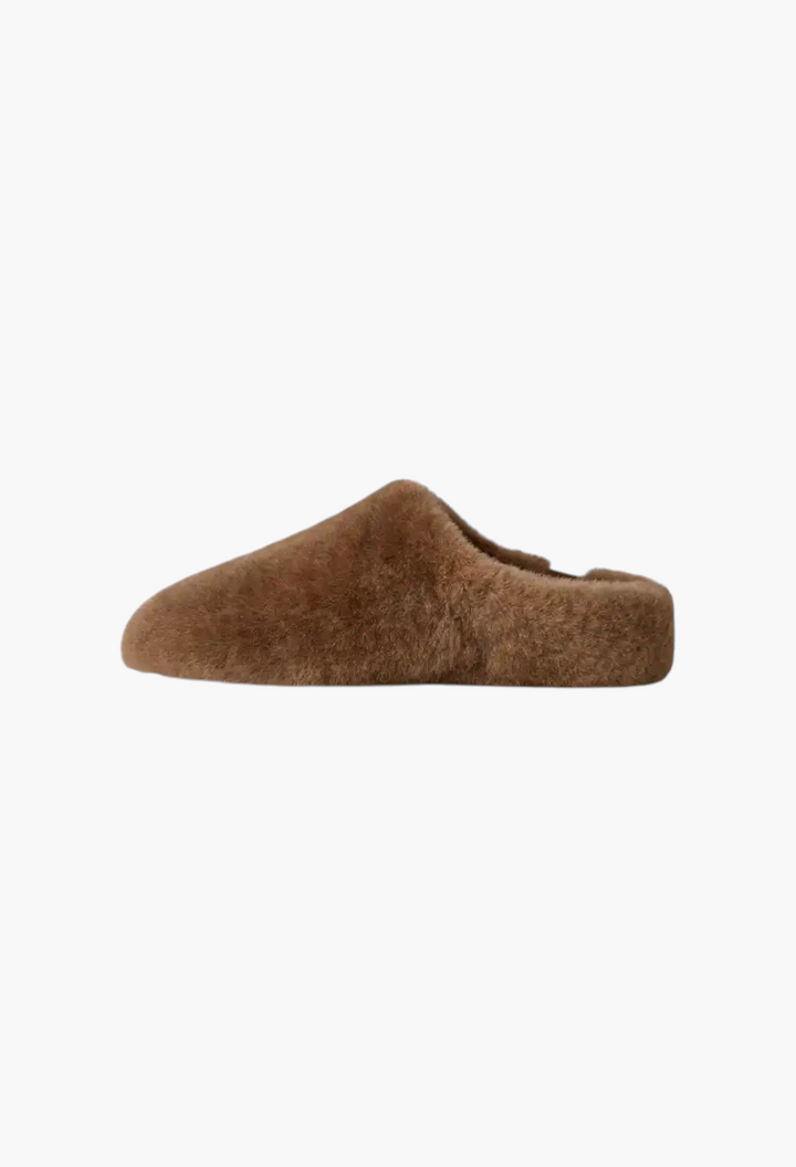 GLAM MODA brown sheepskin slip-on slipper with a minimalist design and soft, fluffy texture for indoor or outdoor use.