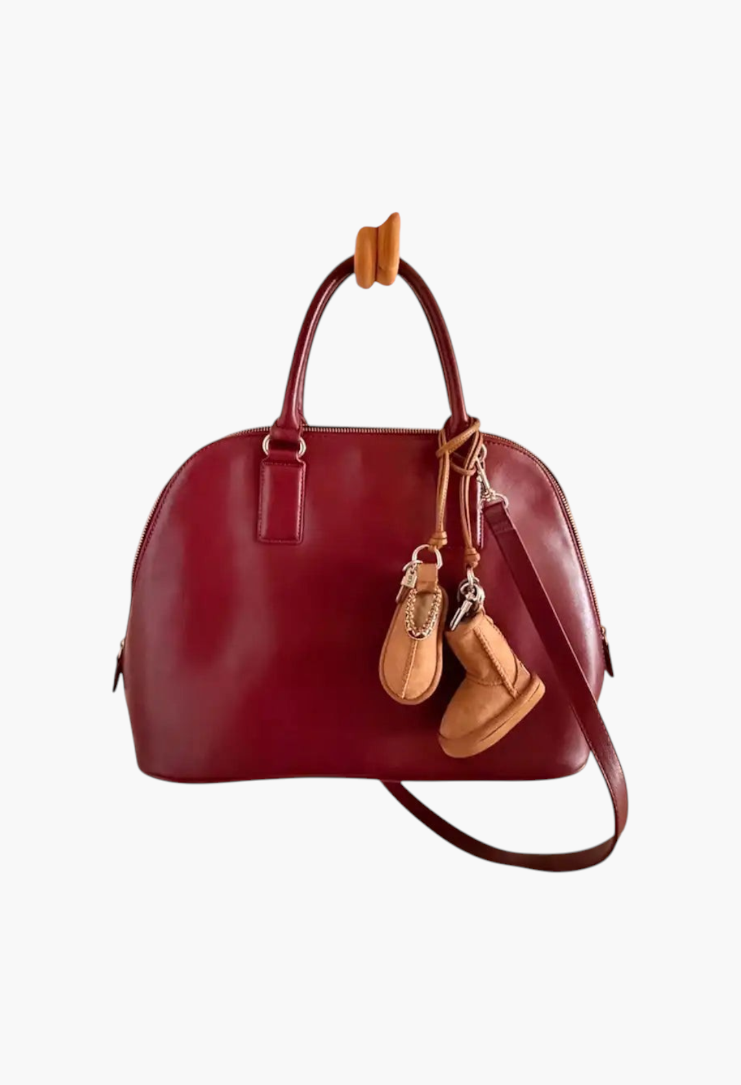 GLAM MODA classic boot charm keychain in tan suede hanging from a deep red leather handbag
