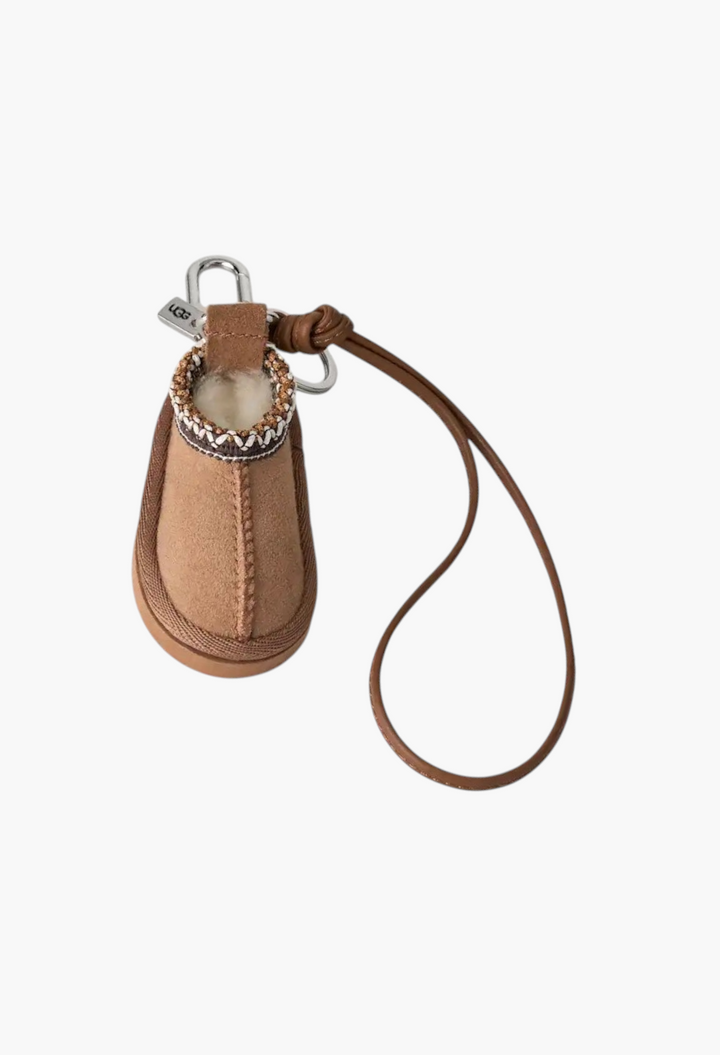 GLAM MODA Tasman slipper charm keychain in tan suede with UGGbraid trim, sheepskin lining, and brown PU leather strap.