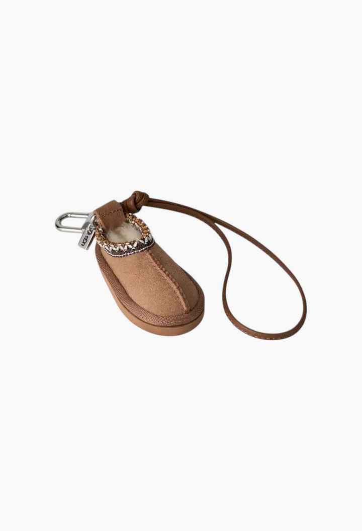 GLAM MODA Tasman slipper charm keychain in chestnut suede with UGGbraid detail, metal ring, and brown leather strap.