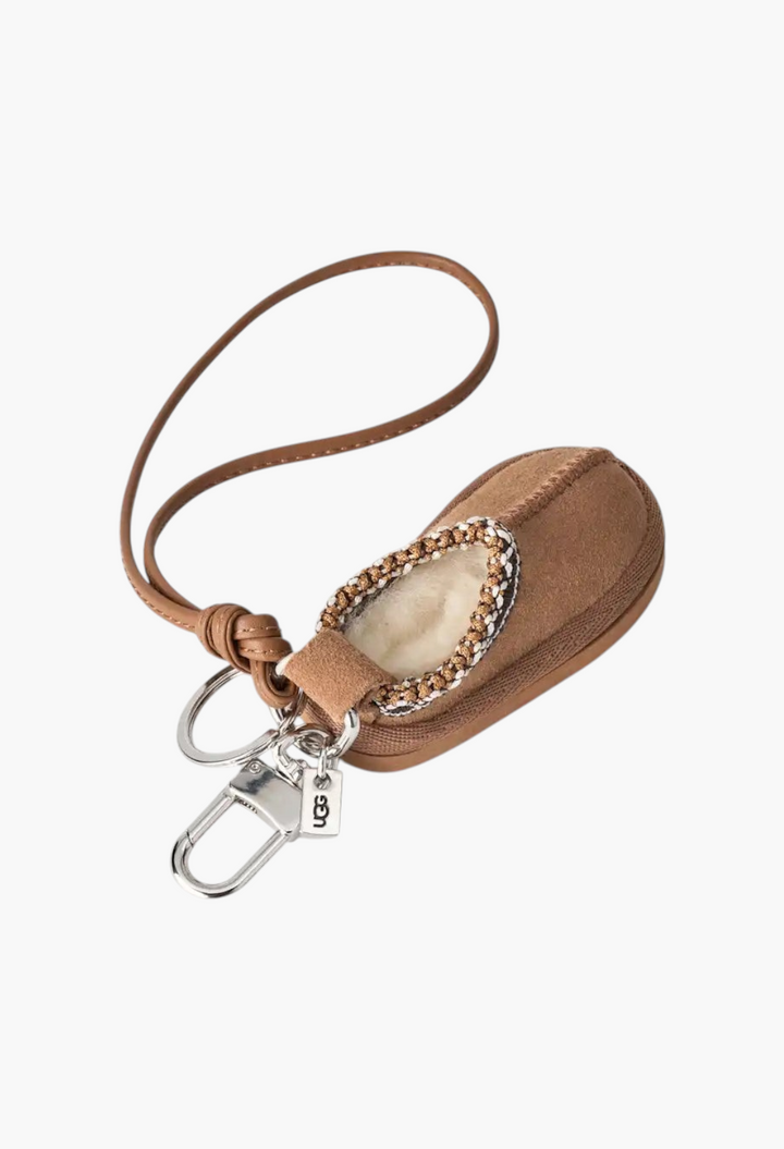 GLAM MODA Tasman slipper charm keychain in tan suede with sheepskin lining, UGGbraid detail, and metal hardware.