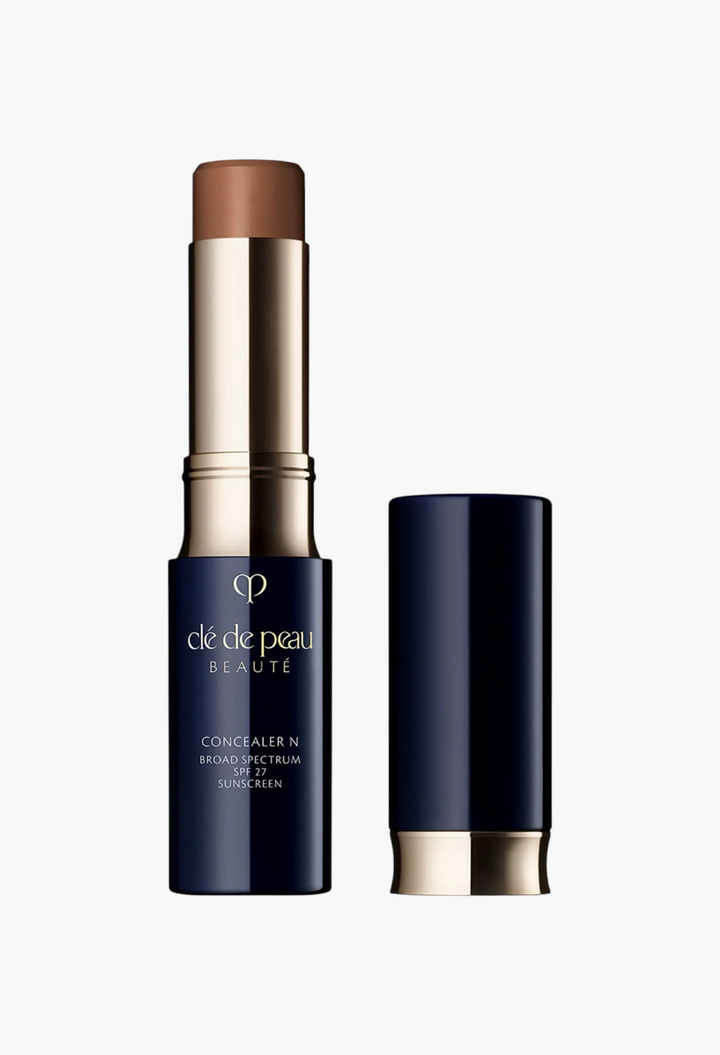 GLAM MODA Concealer SPF 27 stick in a dark brown shade with a navy blue and gold twist-up tube packaging.