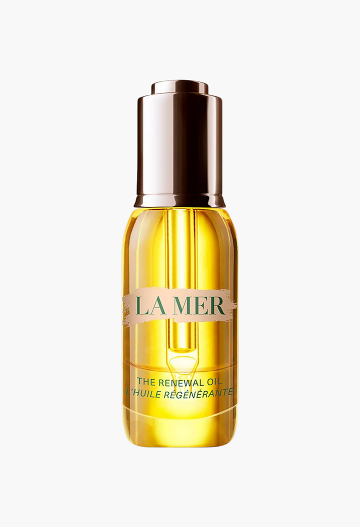 GLAM MODA La Mer The Renewal Oil in a clear glass bottle with a gold dropper cap, featuring a golden facial oil.