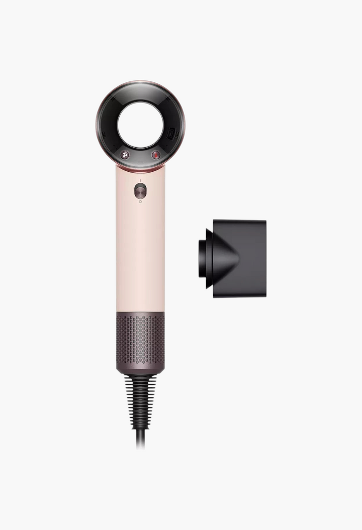 GLAM MODA Supersonic travel hair dryer in ceramic pink with a styling concentrator attachment on a white background.