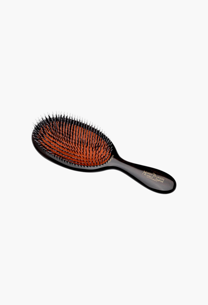GLAM MODA Mason Pearson Popular hairbrush with dark wood handle, rubber cushion, and boar and nylon bristles.