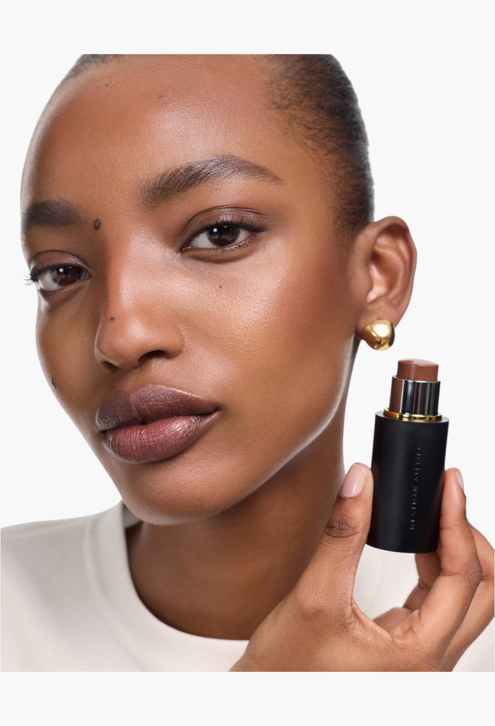 GLAM MODA Face Trace Contour Stick held by a model with a natural makeup look and gold earrings
