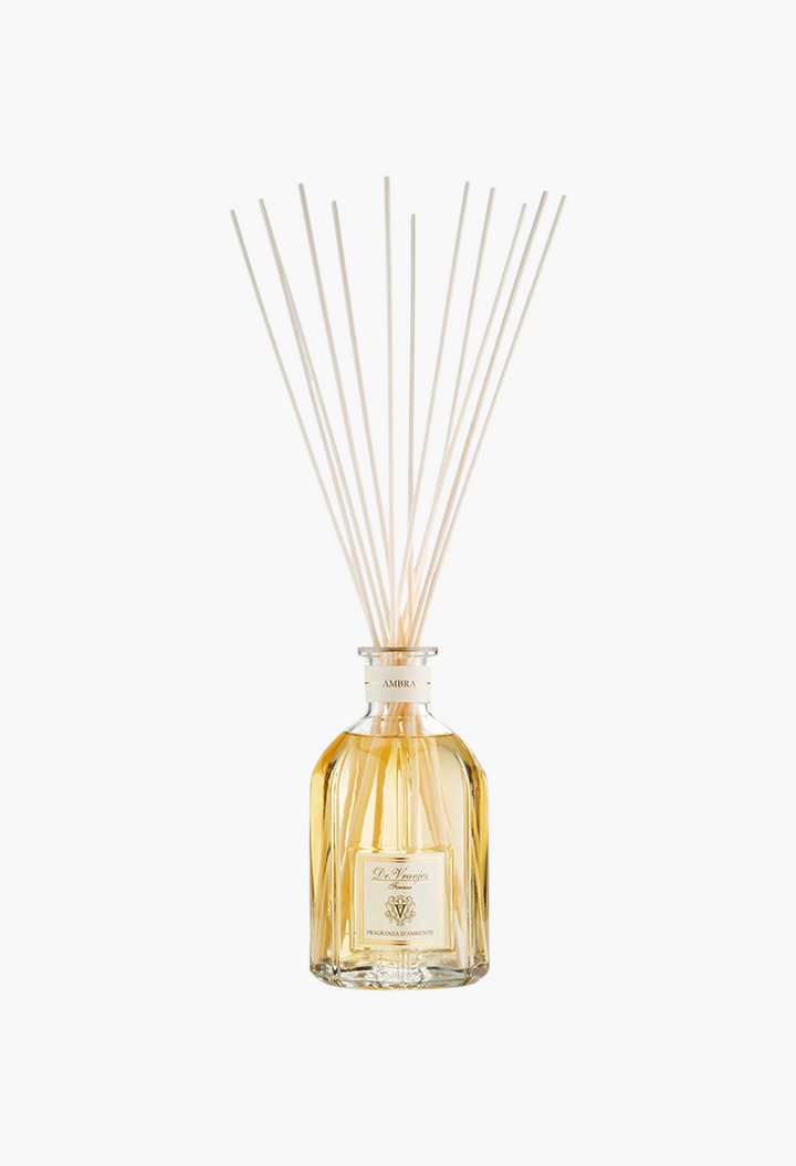 GLAM MODA Dr. Vranjes Ambra reed diffuser in a clear glass bottle with amber fragrance oil and wooden sticks