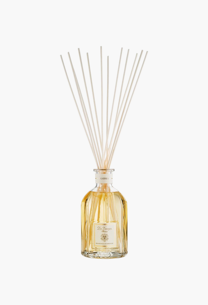 GLAM MODA Dr. Vranjes Ambra reed diffuser in a clear glass bottle with amber fragrance oil and wooden sticks