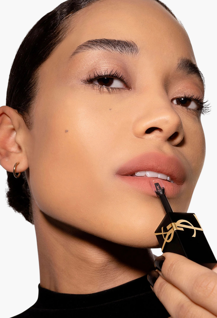 GLAM MODA model applying Yves Saint Laurent The Inks Blurring Matte Liquid Lip Stain in a soft nude matte shade