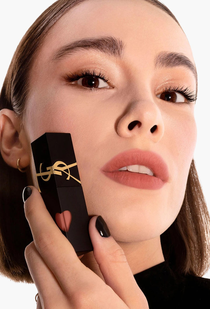 GLAM MODA Yves Saint Laurent The Inks Blurring Matte Liquid Lip Stain in a soft nude shade held by a model