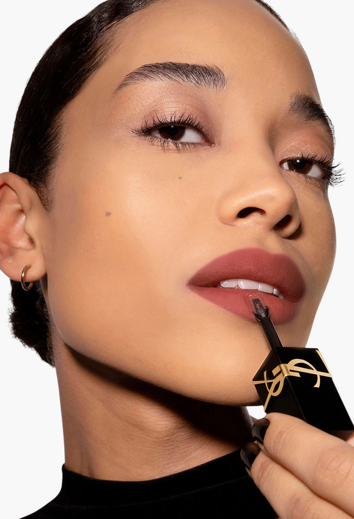 GLAM MODA model applying Yves Saint Laurent The Inks Blurring Matte Liquid Lip Stain in a soft mauve matte shade