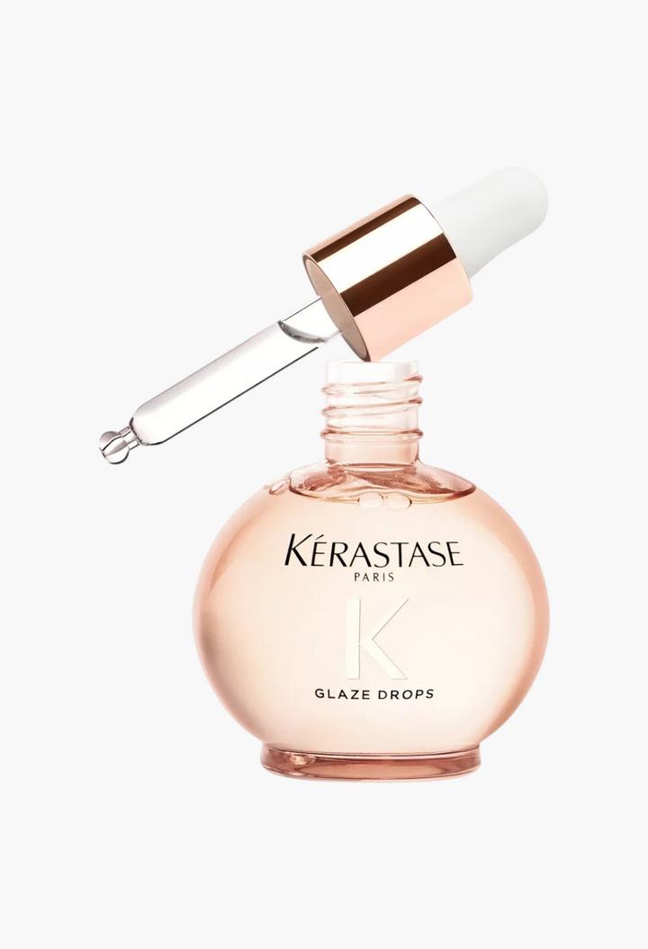 GLAM MODA Kerastase Gloss Absolu Glaze Drops in a round glass bottle with a rose gold dropper for shiny hair.