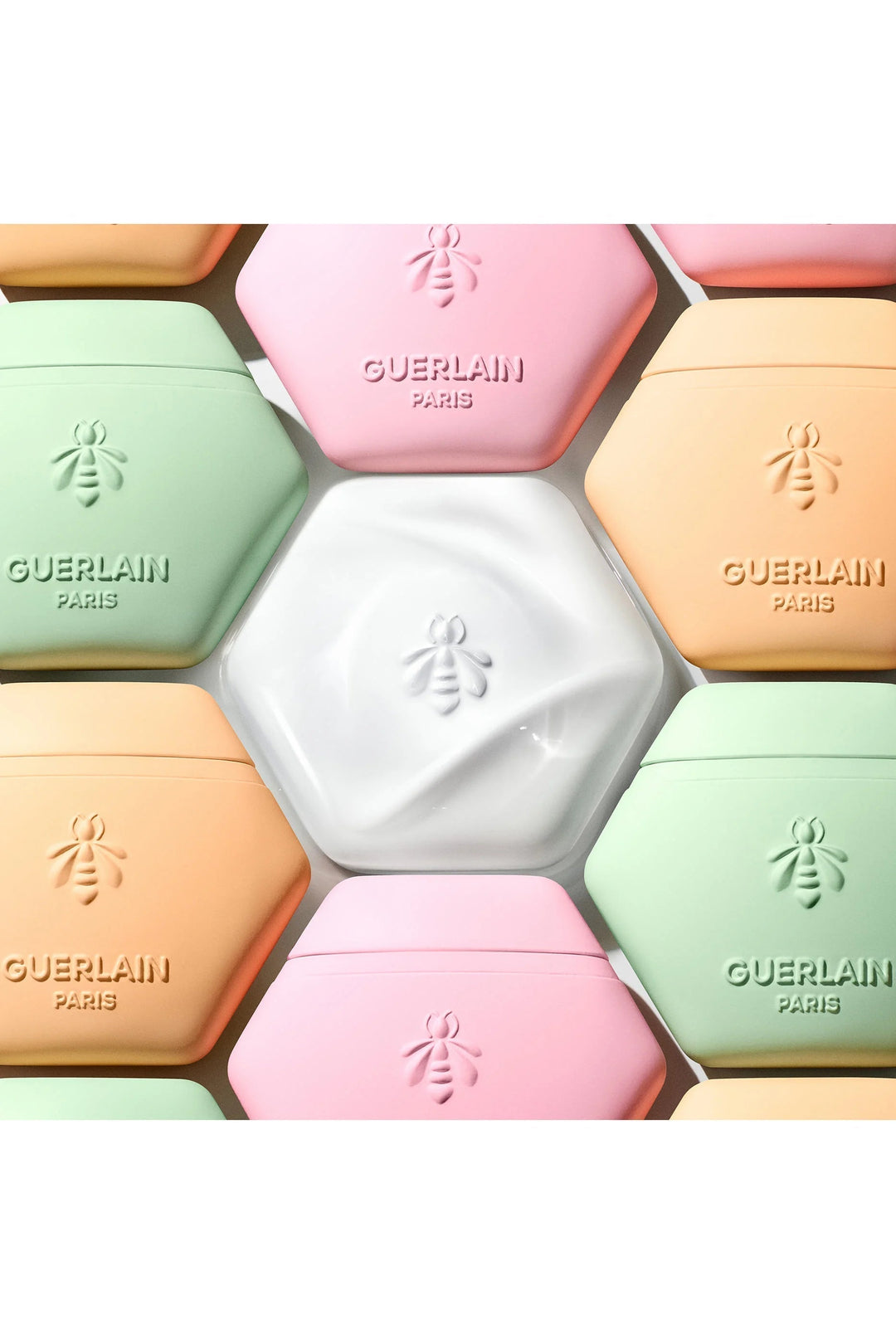 GLAM MODA Guerlain Aqua Allegoria Florabloom hand cream tubes in pastel honeycomb shapes with bee logo embossing.