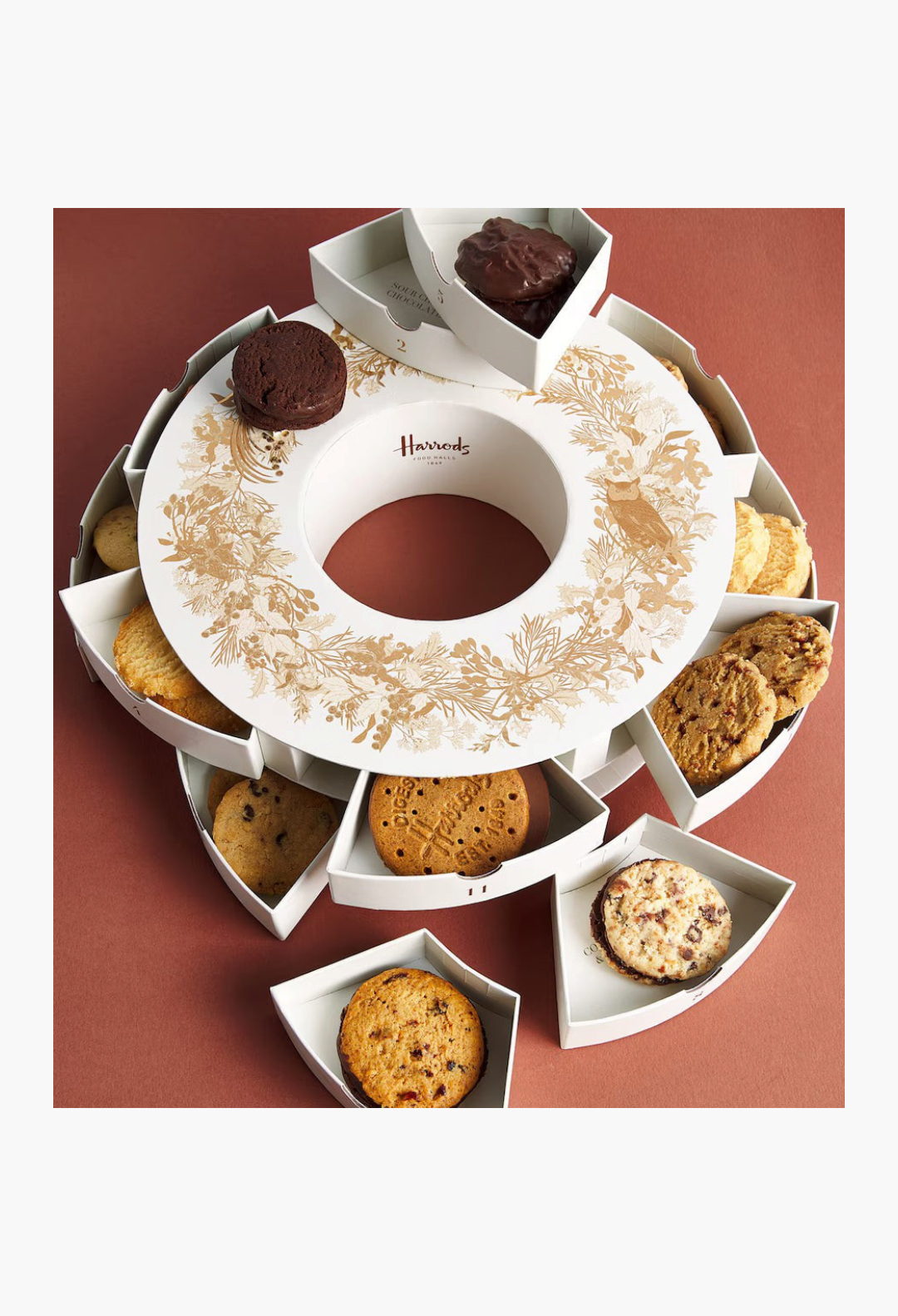 GLAM MODA Harrods 12 Days of Biscuits advent calendar featuring a circular white tin with festive gold illustrations.