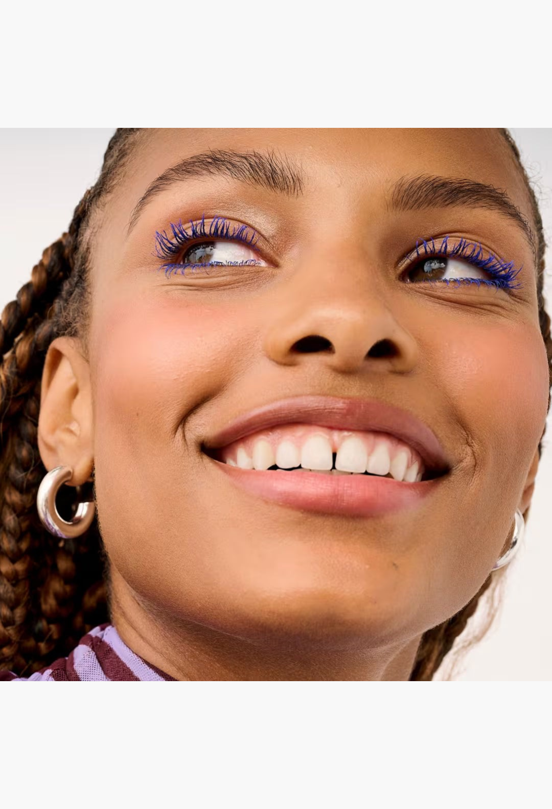 GLAM MODA model wearing vibrant blue volumizing mascara for dramatic lash length and lift