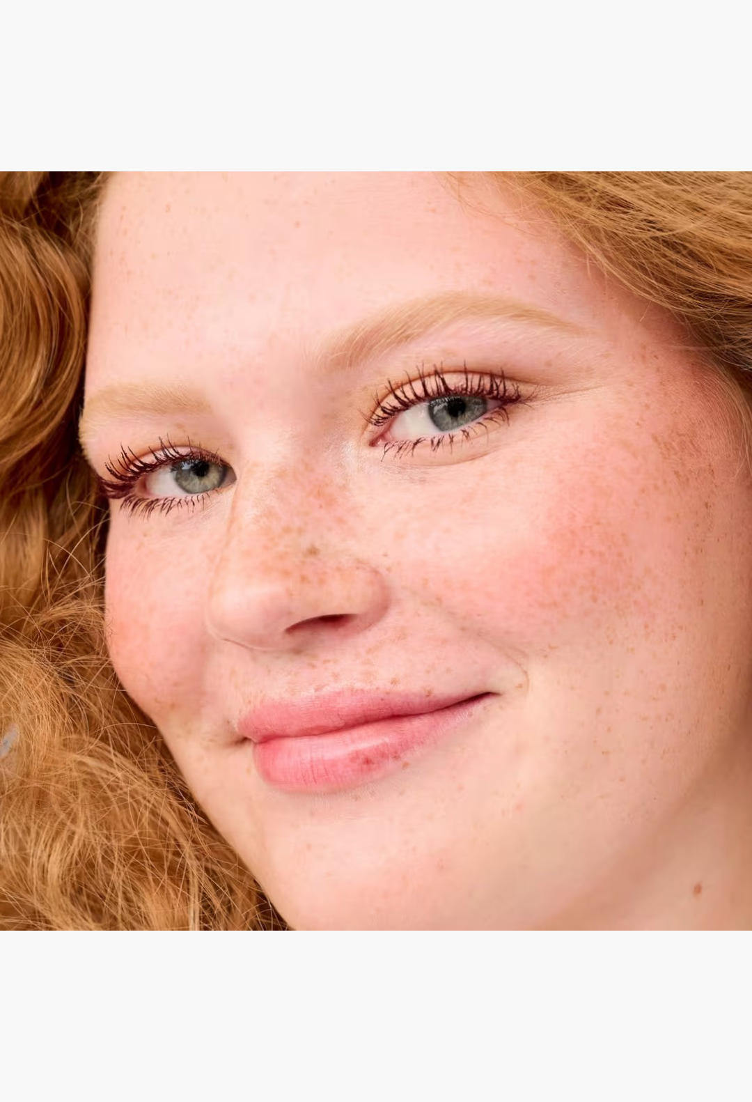 GLAM MODA model with red hair wearing Benefit BADgal BANG! volumizing mascara for lifted and lengthened lashes
