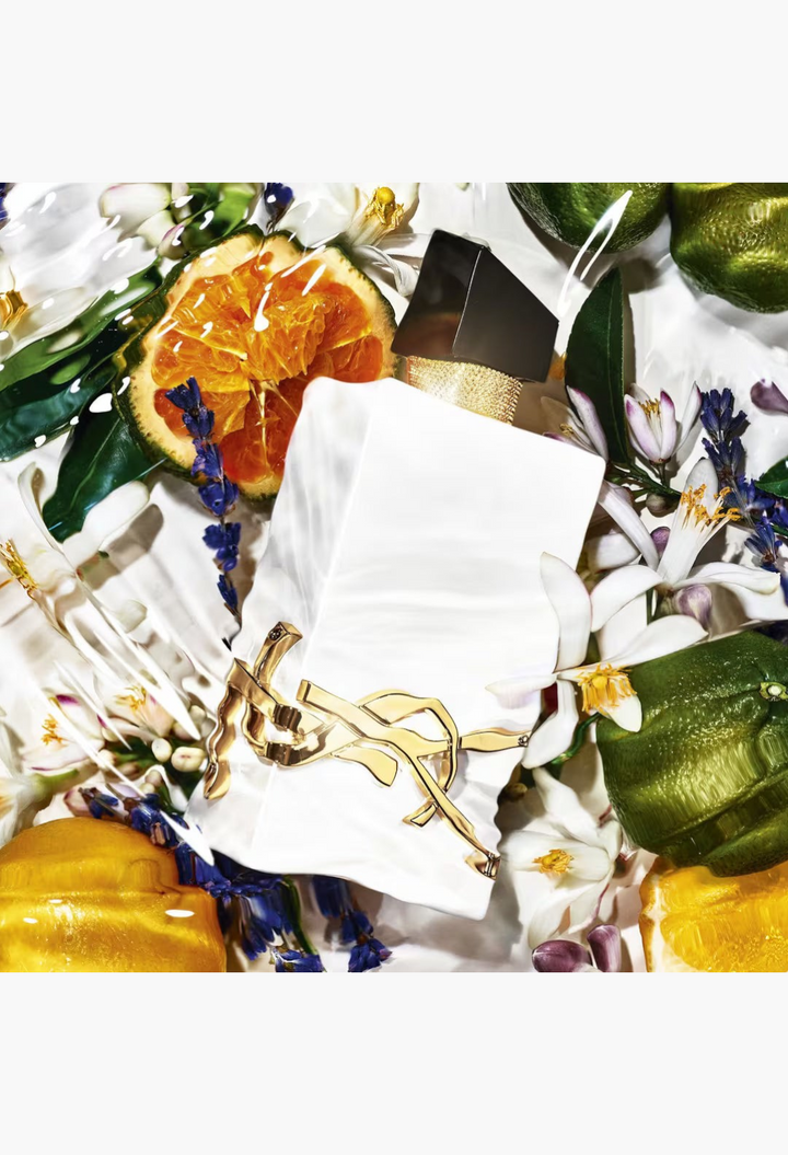 GLAM MODA Yves Saint Laurent Libre L’Eau Nue perfume bottle surrounded by fresh citrus, orange blossoms, and lavender.