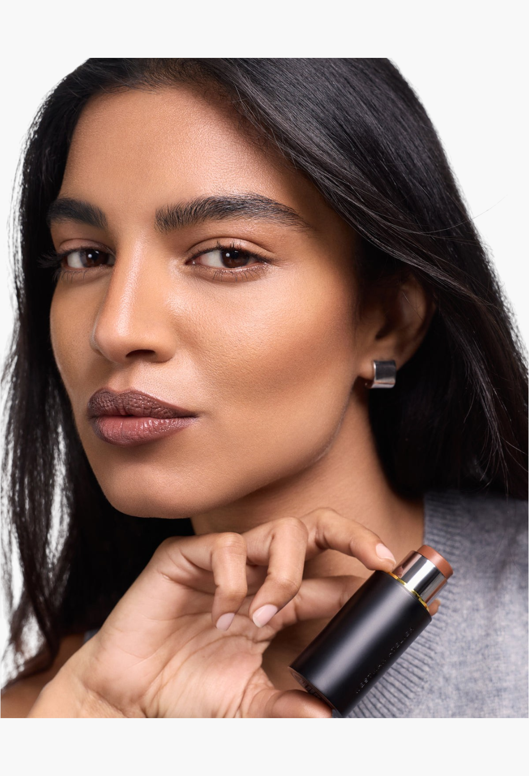 GLAM MODA Face Trace Contour Stick held by a model with natural, defined cheekbones and a creamy, blendable finish.