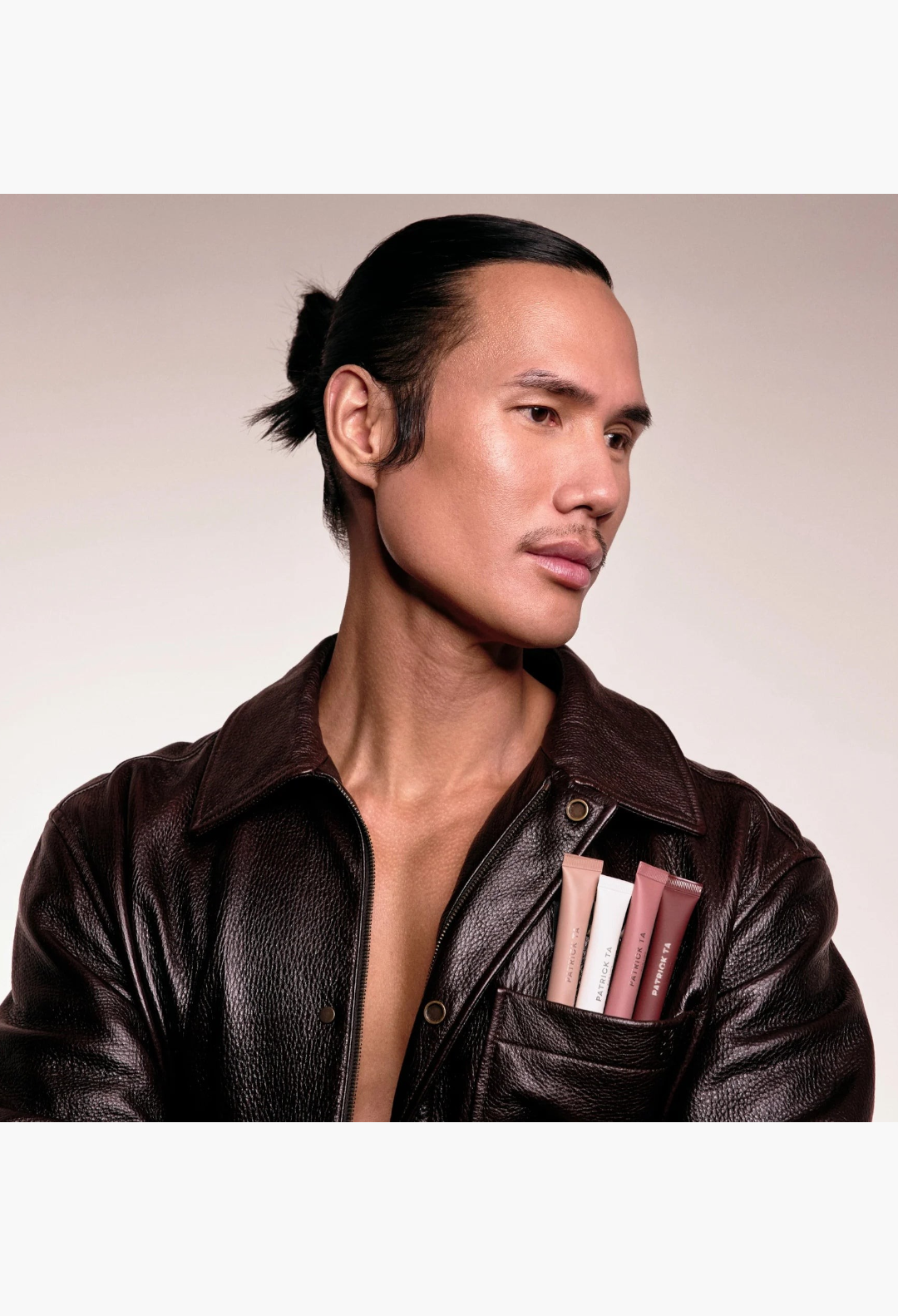 GLAM MODA Mini Major lip balm tubes tucked into the pocket of a man wearing a dark brown leather jacket