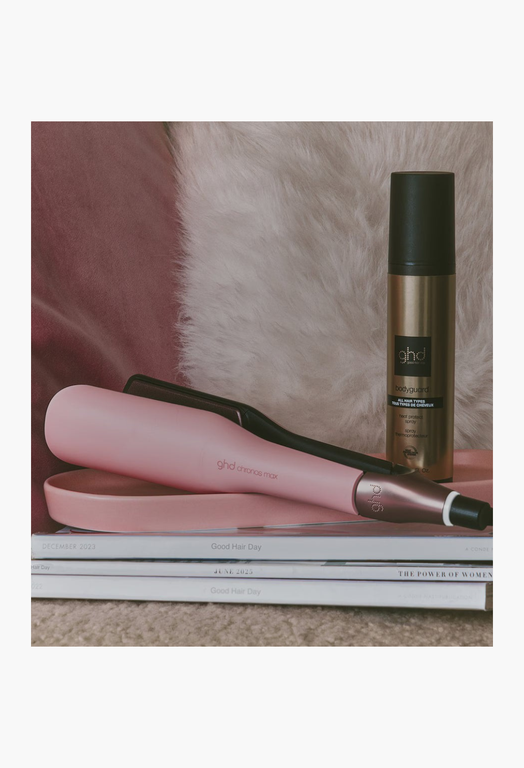 GLAM MODA pink ghd Chronos Max wide plate hair straightener and heat protect spray resting on stacked magazines