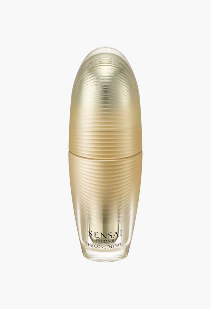 GLAM MODA Sensai Ultimate The Concentrate anti-ageing essence in a sleek gold bottle with a textured cap.
