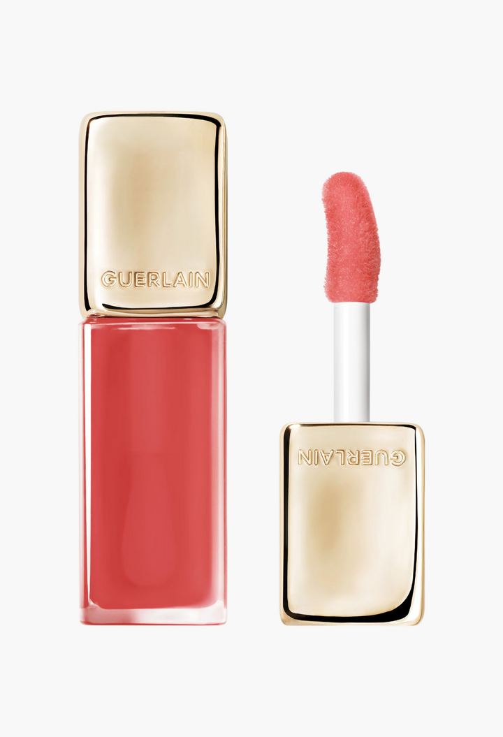GLAM MODA Guerlain KissKiss Bee Glow Oil in a coral pink shade with a gold cap and soft applicator wand
