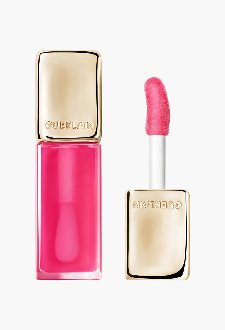 GLAM MODA Guerlain KissKiss Bee Glow Oil in a vibrant pink shade with a gold cap and soft applicator wand.