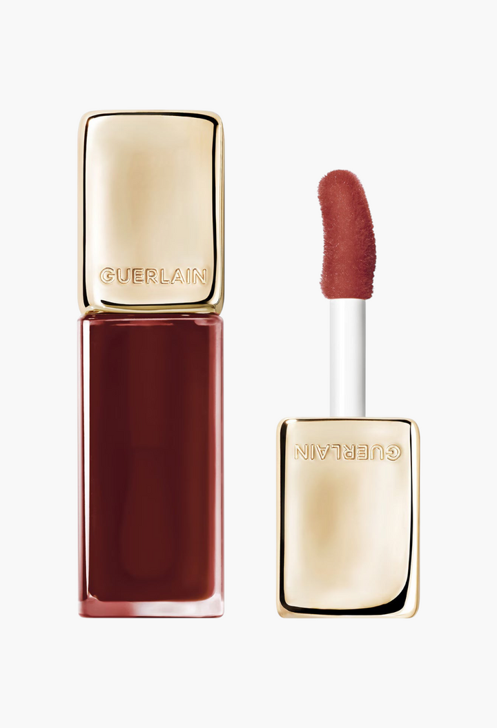 GLAM MODA Guerlain KissKiss Bee Glow Oil in a deep red shade with a gold cap and applicator wand.