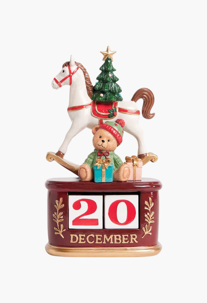 GLAM MODA festive advent calendar featuring a white rocking horse, a teddy bear, and a Christmas tree on a red base.