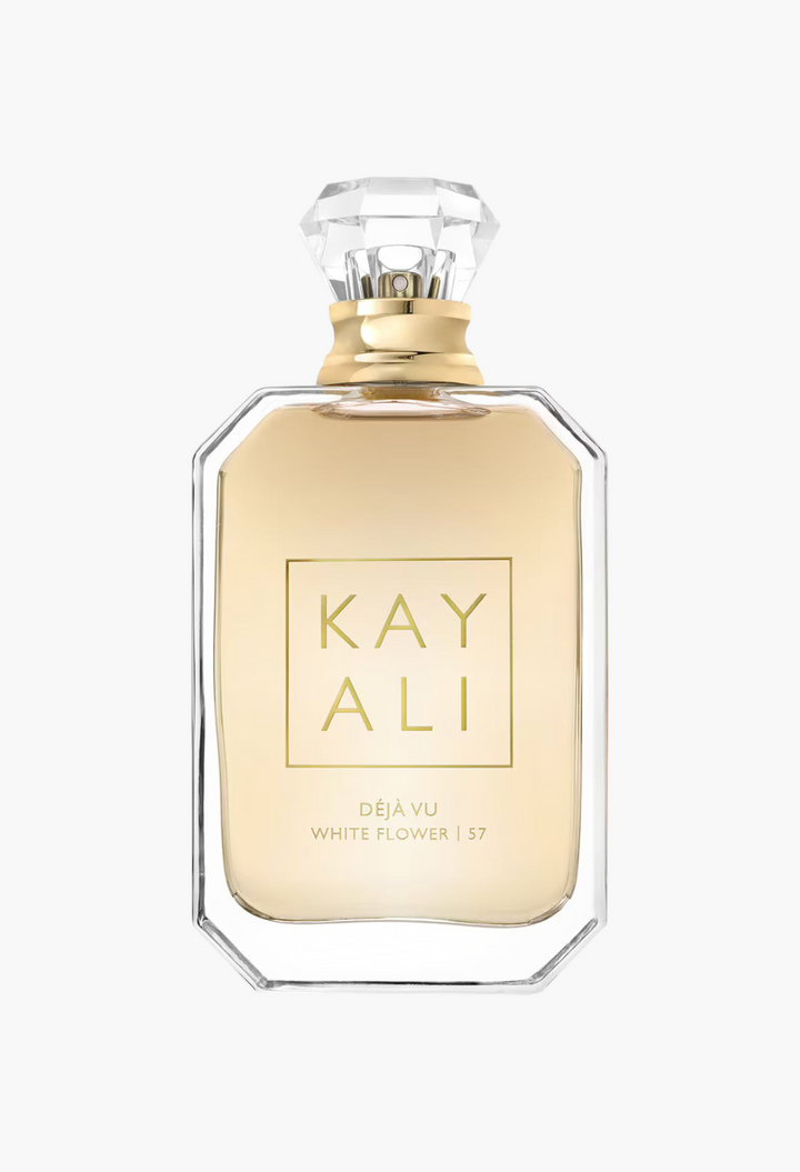 GLAM MODA Kayali Deja Vu White Flower 57 perfume bottle with a clear glass design, gold liquid, and crystal cap.