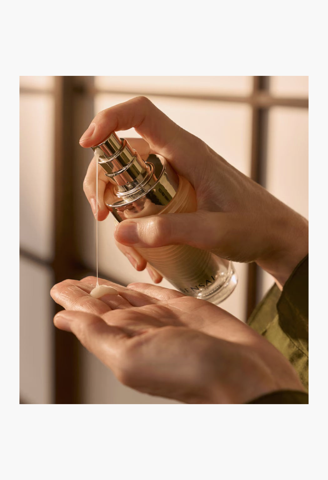 GLAM MODA Sensai Ultimate The Concentrate anti-ageing essence being dispensed into a hand, showing its nectar-like texture.