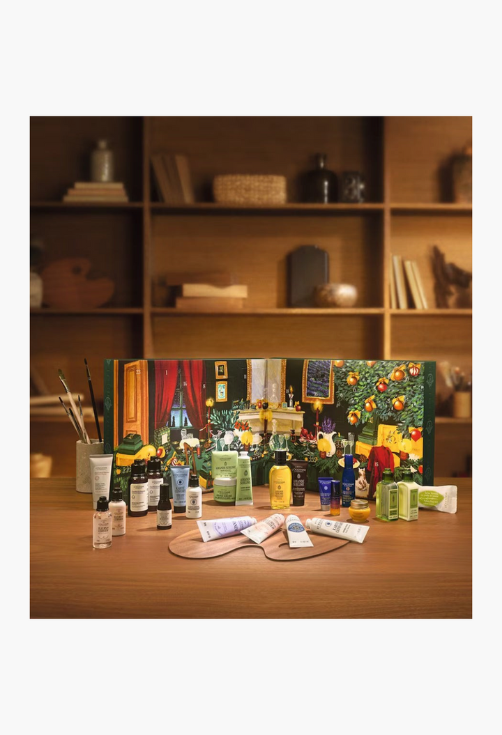 GLAM MODA L'Occitane Classic Advent Calendar featuring 24 assorted beauty, skincare, and bath products on a wooden tray