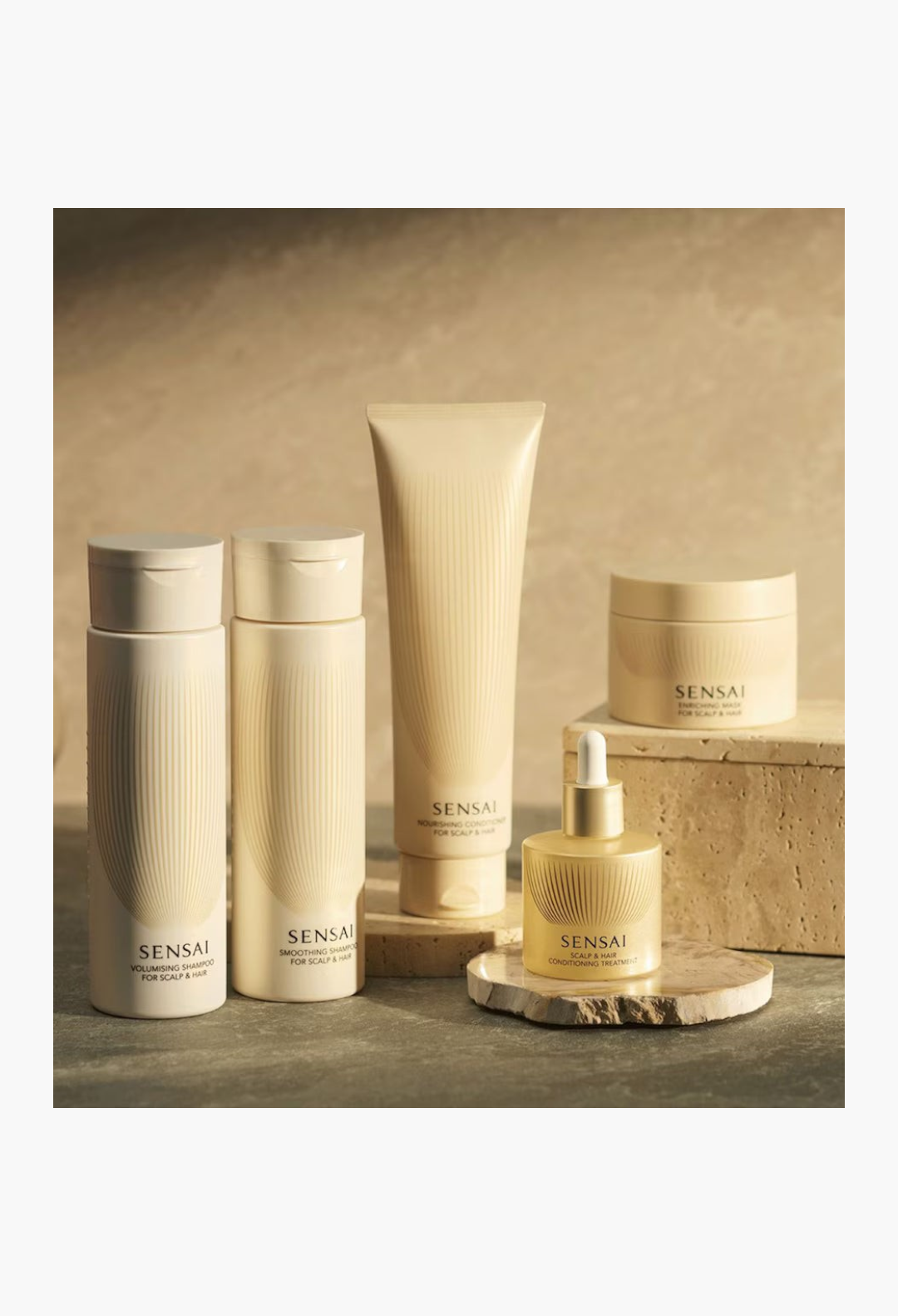 GLAM MODA collection of SENSAI hair care products in beige bottles and jars displayed on stone pedestals