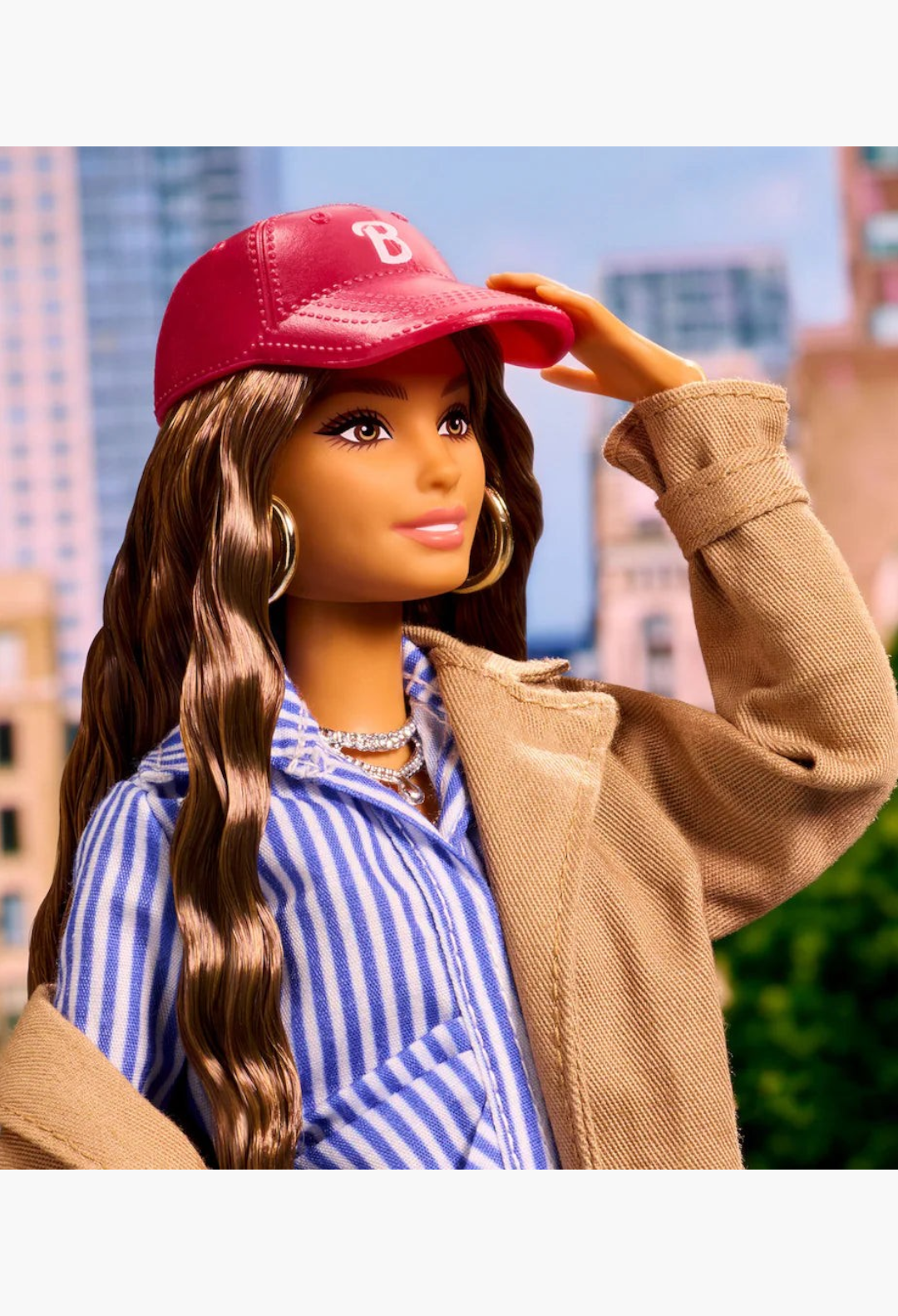 GLAM MODA New York Fashion Week Barbie doll wearing a red cap, beige coat, and blue striped shirt in a city setting.