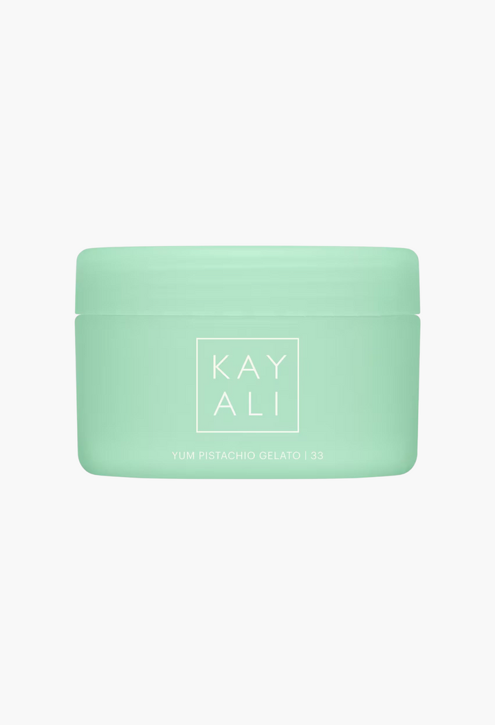 GLAM MODA KAYALI Yum Pistachio Gelato 33 Silk Soufflé Body Cream in a light green jar with white branding.