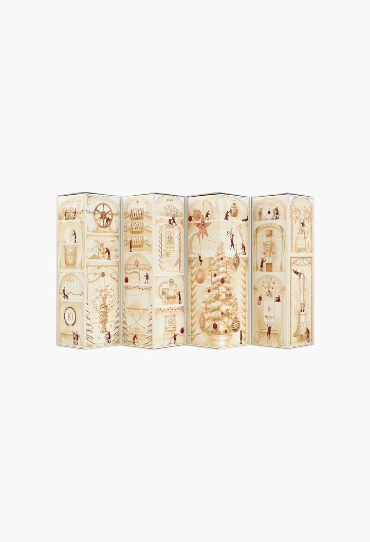 GLAM MODA Neuhaus chocolate advent calendar featuring festive illustrations of a Christmas tree and holiday scenes.